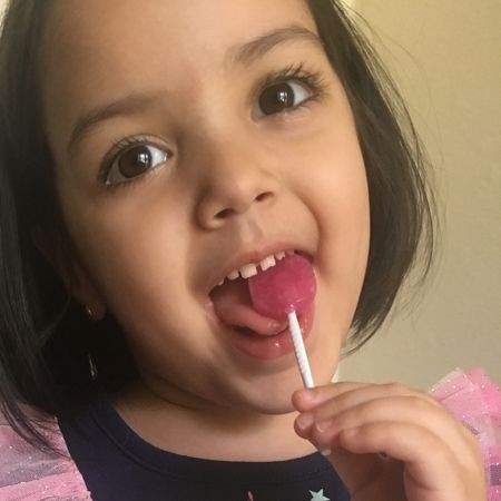 little girl licks a lollipop